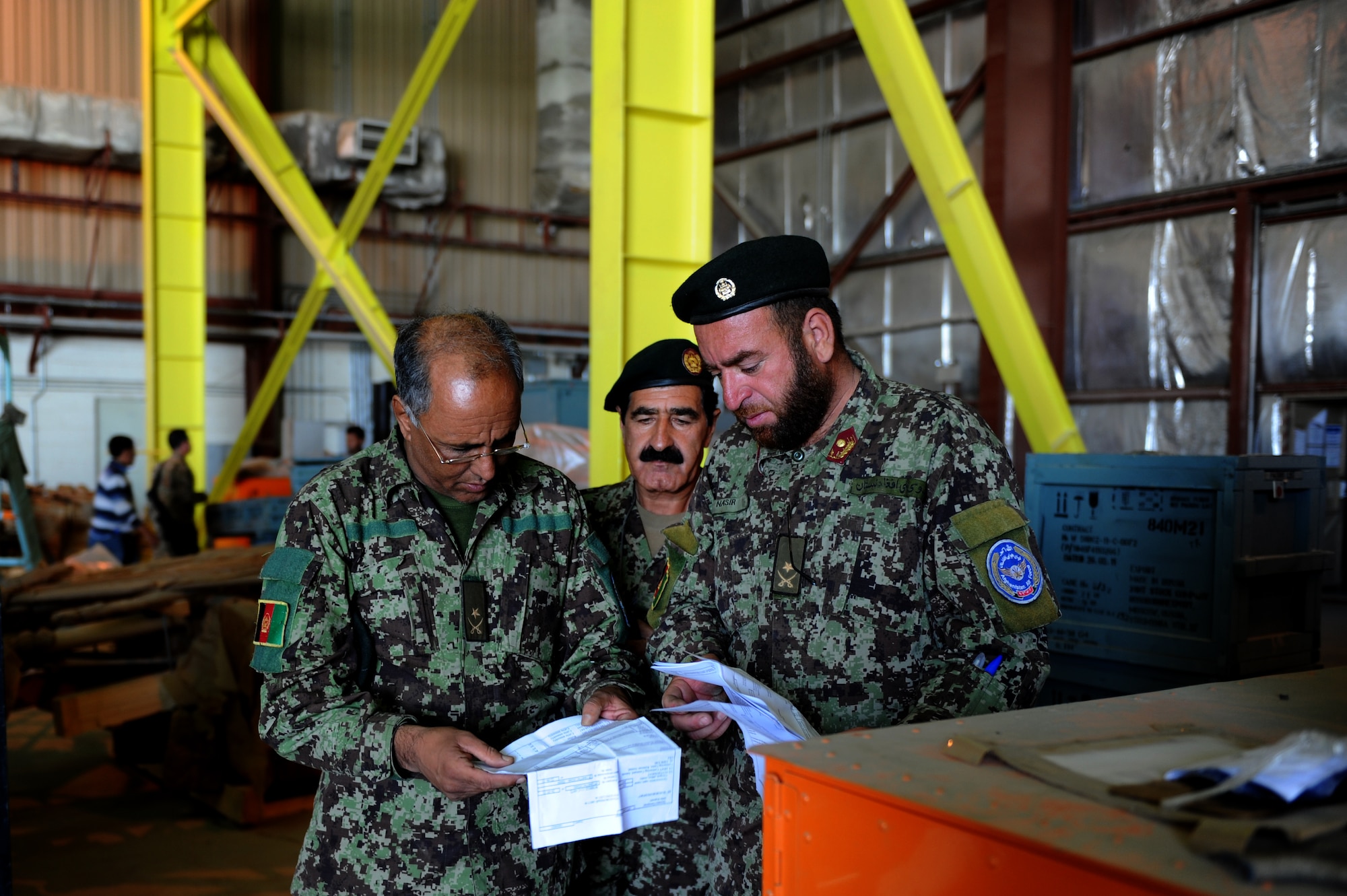 Maj. Dawod, Maj. Omear and Maj. Nasir, Afghan Air Force soldiers, look over a supply list while conducting an aircraft parts inventory. Over the last several months, the Afghan air force has been conducting a project involving the inventory of more than 47,000 parts. Once the inventory is complete, the parts will be distributed to other bases in Afghanistan. (U.S. Air Force photo Staff Sgt. Melissa K. Mekpongsatorn)