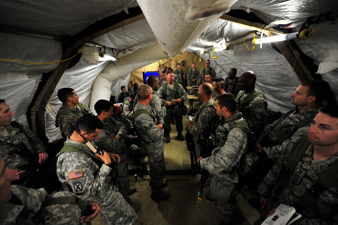 FORT POLK, La. – U.S. Air Force Col. Darren Sprunk,  570th Contingency Response Group commander, speaks to his team leaders during a shift change in the command post on Geronimo Landing Zone, Fort Polk, La. Oct 15, 2012.   The CRG was supporting Joint Readiness Training Exercise Decisive Action. The exercise includes emphasis on joint forcible entry, phased deployment with an airborne parachute operation, a combined noncombatant evacuation, combine arms maneuver, wide area security, unconventional warfare and unified land operations in a joint, interagency, intergovernmental and multinational environment. (U.S. Air Force photo by Tech. Sgt.  Parker Gyokeres) (Released)