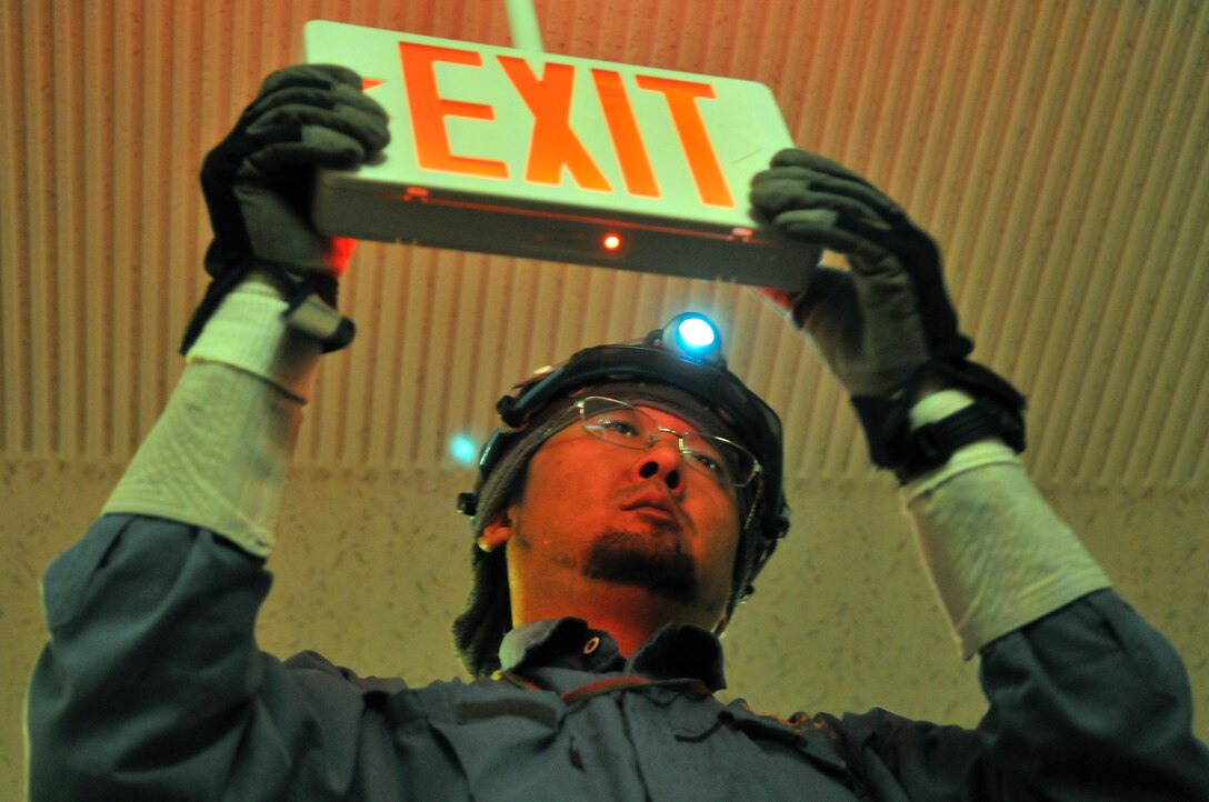 Wataru Kaga, Japanese contractor, snaps the outer cover of an exit sign into place after installing energy efficient light emitting diodes at the Misawa Club Complex at Misawa Air Base, Japan, Oct. 19, 2012. The newly installed LEDs have a 7-year lifespan and will save the club approximately $1,500 in labor costs and bulbs a month. (U.S. Air Force Photo by Tech. Sgt. Phillip Butterfield)