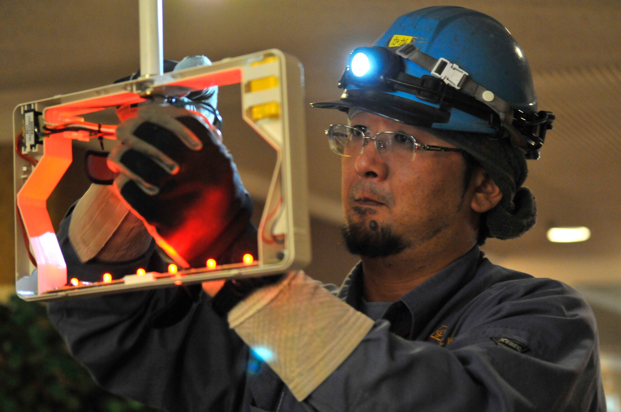 Wataru Kaga, Japanese contractor, energizes a row of light emitting diodes in an exit sign at the Misawa Club Complex at Misawa Air Base, Japan, Oct. 19, 2012. The Misawa Club Complex will be changing more than 1,200 standard bulbs for more energy efficient LEDs, which will save approximately $42,000 over a 7-year period. (U.S. Air Force Photo by Tech. Sgt. Phillip Butterfield)