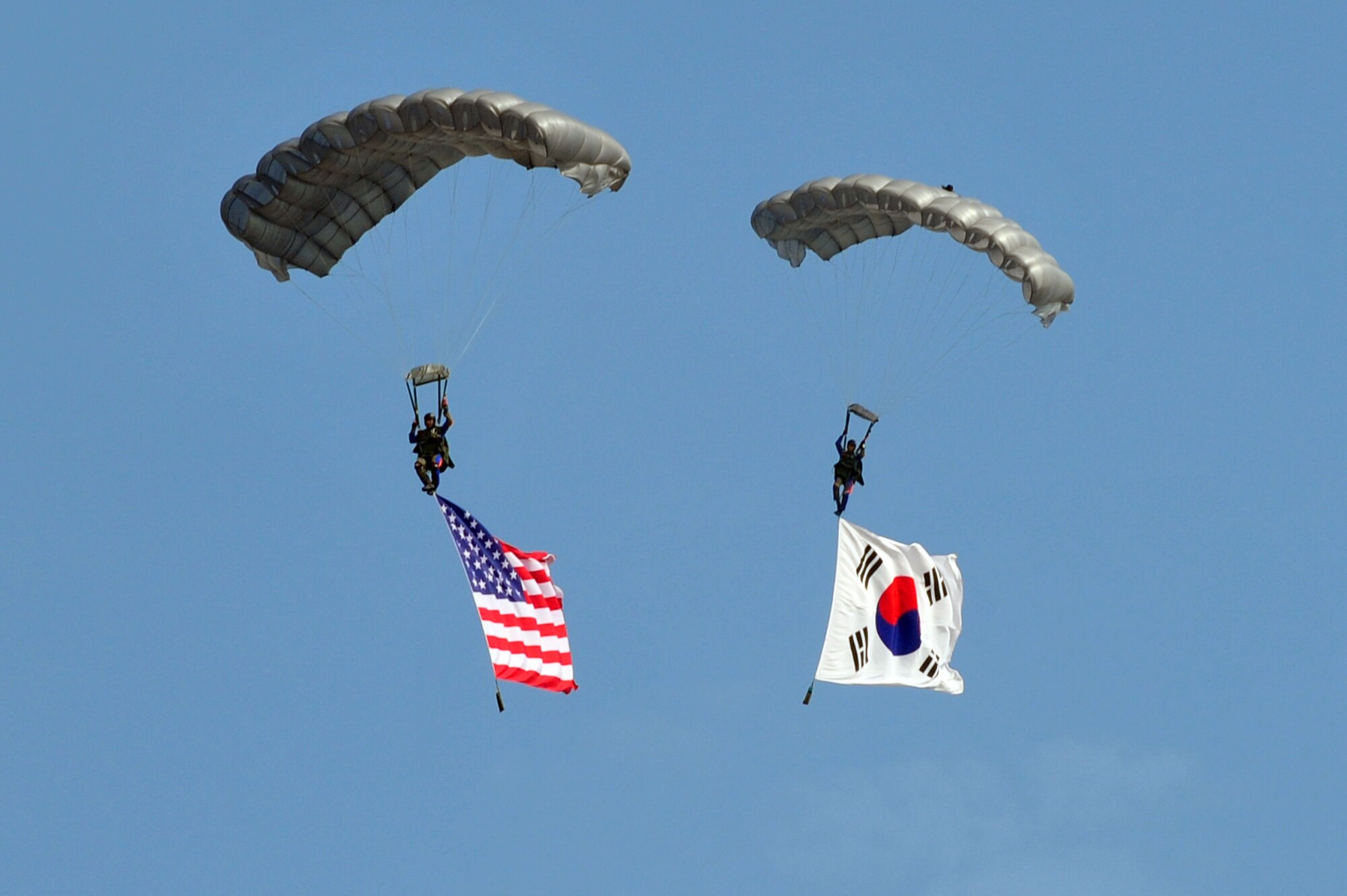Members from the Republic of Korea Parachute Demo Team descend with the American and ROK flags as part of the opening ceremony during Air Power Day 2012  on Osan Air Base, ROK, Oct. 21, 2012. Air Power Day 2012 represents an annual opportunity for the United States to showcase its military personnel and unique equipment to a global audience personnel. (U.S. Air Force photo/Airman 1st Class Alexis Siekert)