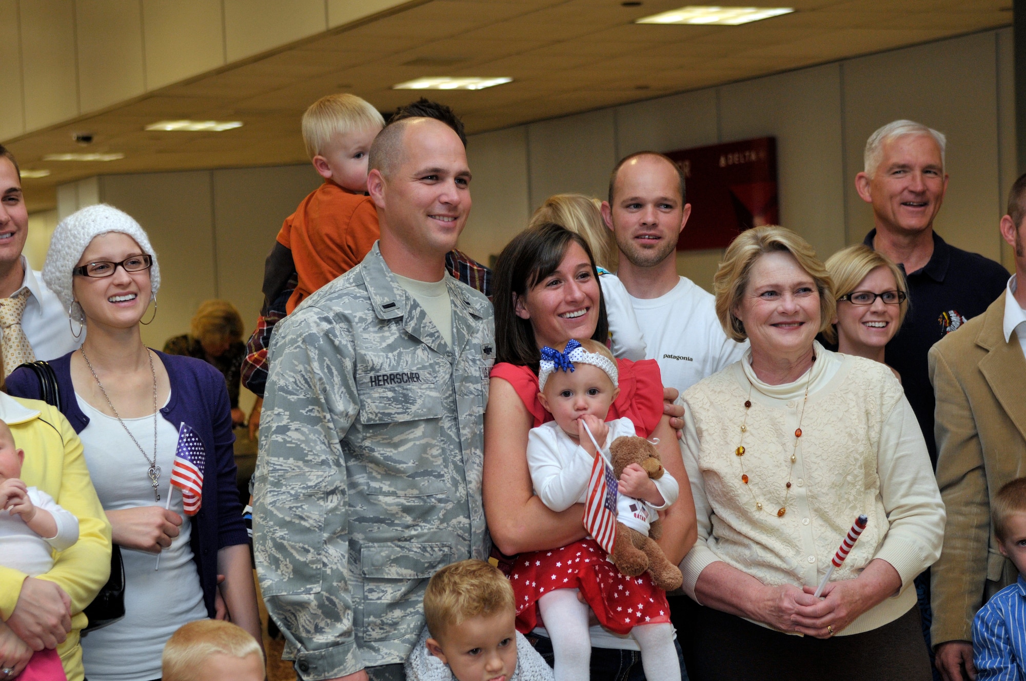 1st Lt. Brian Herrscher, 130th Engineering Installation Squadron, poses for a photo with his family at the Salt Lake City International Airport after returning from a six-month deployment to the Middle East on Sunday Oct. 21, 2012. Herrscher, along with 13 others from the 130th EIS were deployed to the Middle East in support of Operation Enduring Freedom. (U.S. Air Force Photo by Tech. Sgt. Jeremy Giacoletto-Stegall/Released)