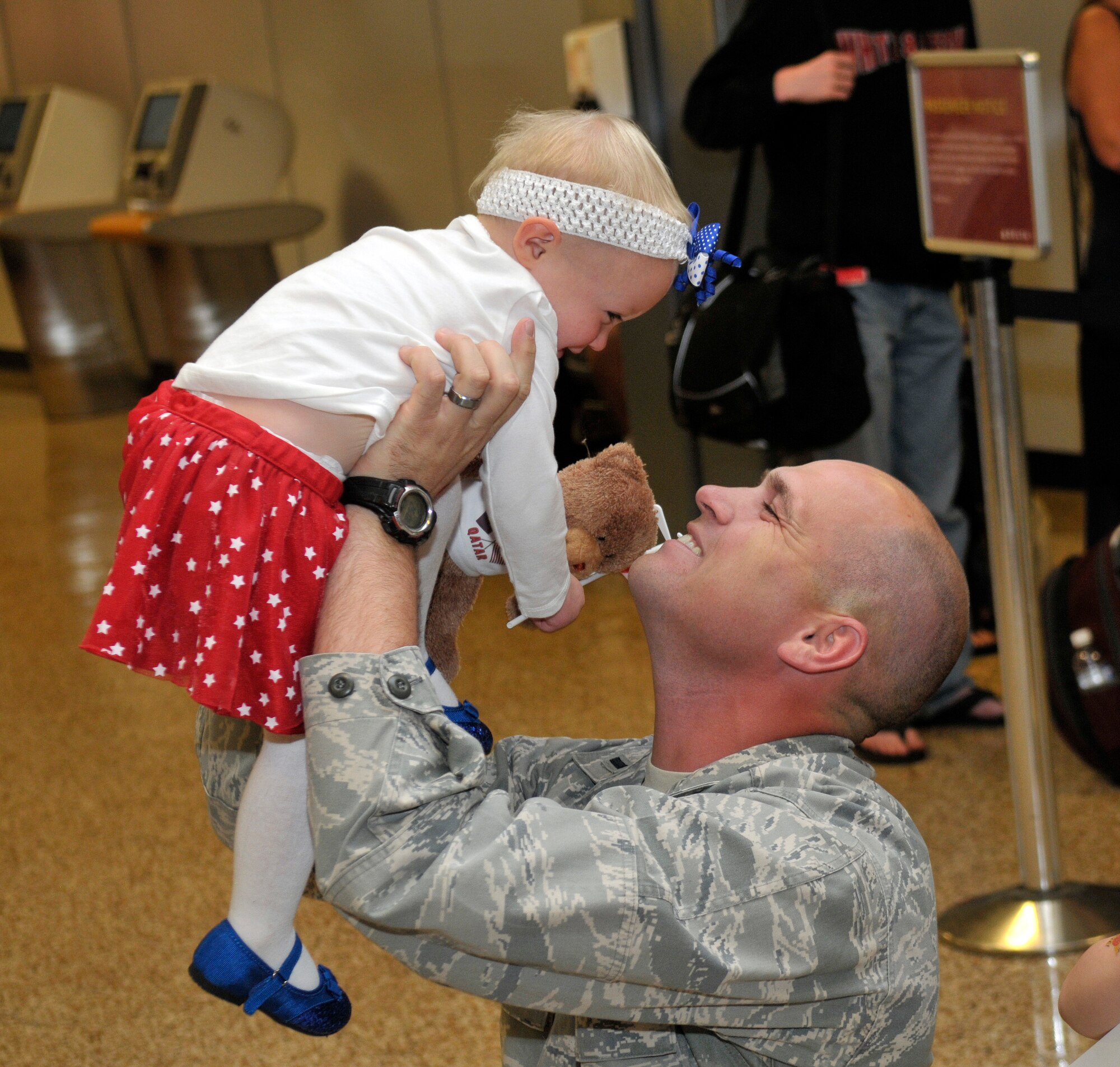 1st Lt. Brian Herrscher, 130th Engineering Installation Squadron, greets his daughter at the Salt Lake City International Airport after returning from a six-month deployment to the Middle East on Sunday Oct. 21, 2012. Herrscher, along with 13 others from the 130th EIS were deployed to the Middle East in support of Operation Enduring Freedom. (U.S. Air Force Photo by Tech. Sgt. Jeremy Giacoletto-Stegall/Released)