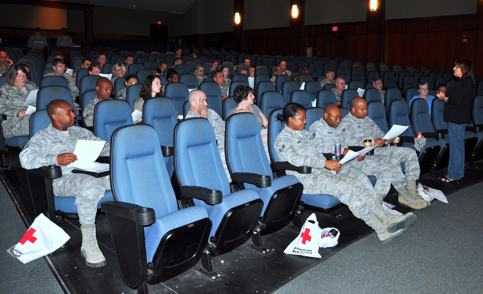 Members of the 315th Airlift Wing's 38th Aerial Port Squadron and their loved ones listen as 315 AW Airman and Family Readiness Chief, Lisa Sweatt delivers a briefing in the base theater here, Saturday.  The Airman and Family Readiness briefing was one of many that the deploying 38th APS members and their families received prior to the squadron's upcoming 6-month deployment to Southwest Asia. (U.S. Air Force photo by 1st Lt. Jeff Kelly)
