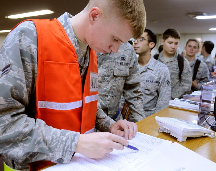 Airman 1st Class John Richardson, 18th Logistics Readiness Squadron traffic management office passenger travel, reviews paperwork of Airmen processing through a deployment line during a Pacific Air Forces readiness inspection on Kadena Air Base, Oct. 22, 2012. Nearly 100 18th Wing Airmen processed through the deployment line while PACAF inspectors observed. (U.S. Air Force photo/Staff Sgt. Laszlo Babocsi)
