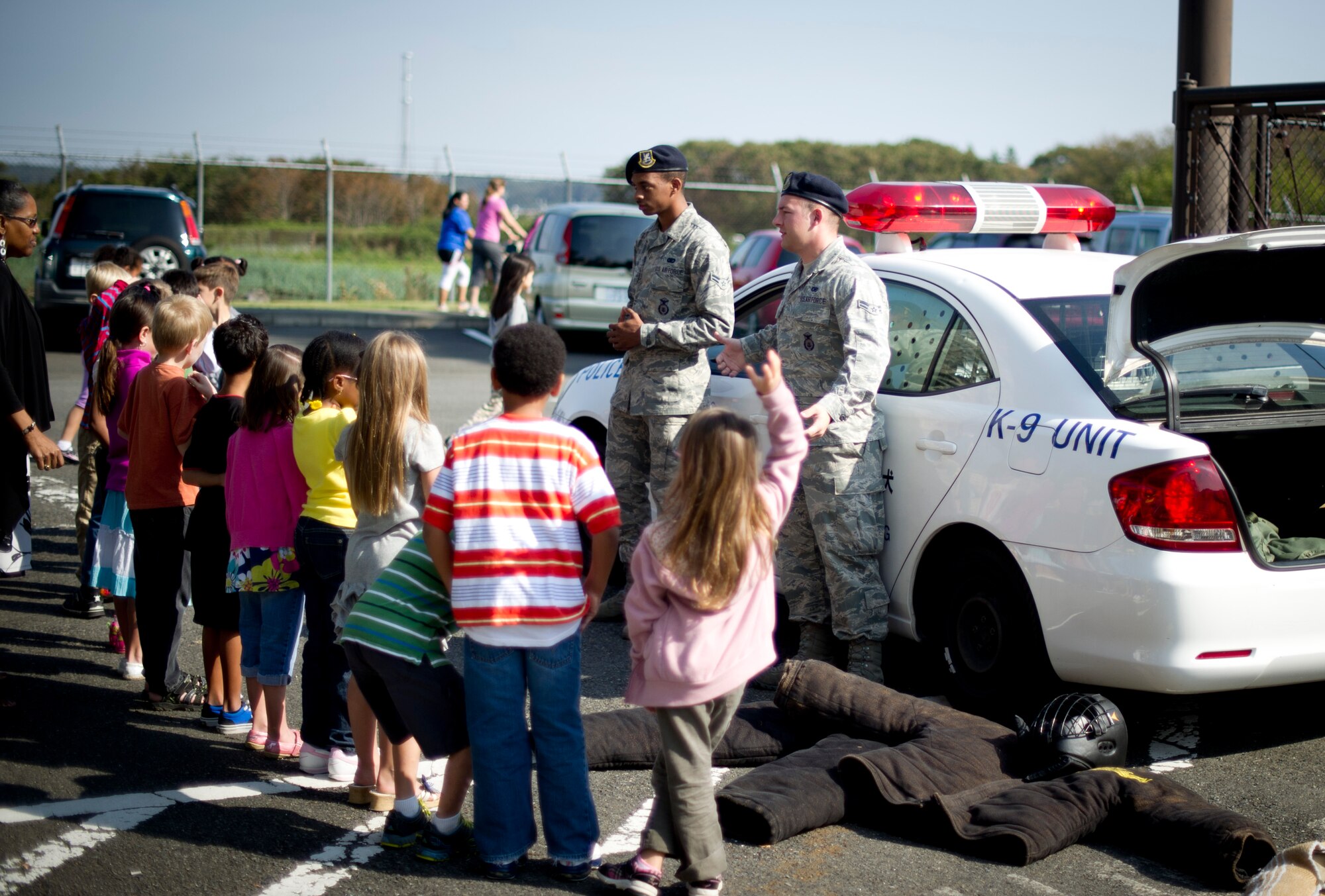 YOKOTA AIR BASE, Japan -- Children from Joan K. Mendel Elementary School ask questions after a dog demonstration during Career Day at Yokota Air Base, Japan Oct. 16, 2012. Children had a chance to talk to the 374th Security Forces personnel about their job and look inside a police car.  (U.S. Air Force photo by Staff Sgt Stacy Moless)    