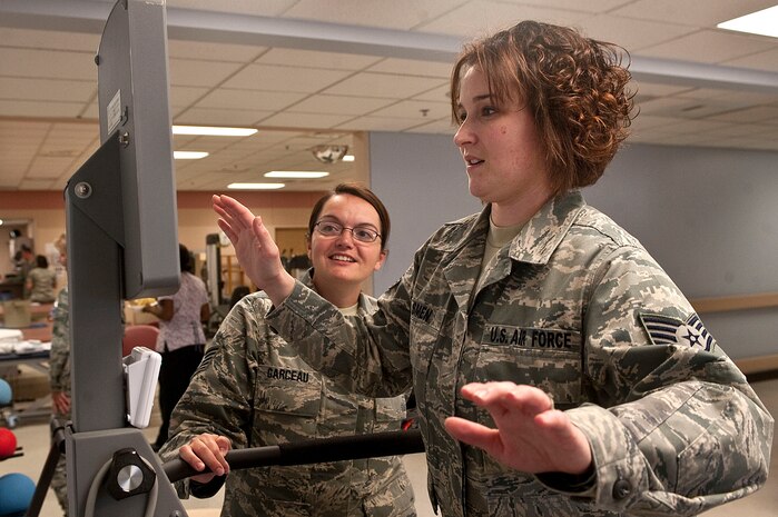 Tech Sgt. Janie Garceau, 99th Medical Operations Squadron physical therapy non-commissioned officer in charge, shows Staff Sgt. Rebecca Smen, 99th MDOS physical therapy technician, how to use a Biodex Balance System during a physical therapy open house Oct. 19, 2012, at Nellis Air Force Base, Nev. Airmen of the 99th MDOS physical therapy section use the Biodex Balance System to help patients improve balance, increase agility, develop muscle tone, and to treat a wide variety of pathologies. (U.S. Air Force photo by Staff Sgt. Christopher Hubenthal)