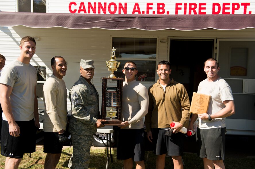 U.S. Air Force Chief Master Sgt. Elliot Smith, 27th Special Operations Civil Engineer Squadron, presents the 1st place trophy to the Air Commandos of team "Dagger" at the conclusion of the 14th Annual Fire Muster at Cannon Air Force Base, N.M., Oct. 19, 2012. This friendly competition allows squadrons to build camradery and gain insight into the day-to-day expectations of Cannon's fire fighters. (U.S. Air Force photo/Staff Sgt. Matthew Plew)
