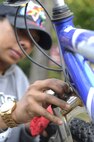 Airman 1st Class Raven Carter, 80th Fighter Squadron, removes rust from a repossessed bicycle during Operation Kunsan Rides Oct. 20, 2012, at Kunsan Air Base, Republic of Korea. Carter was one of more than 15 Airmen Committed to Excellence who showed up to help with the service project and give back to the local community. (U.S. Air Force photo/Senior Airman Brigitte N. Brantley)