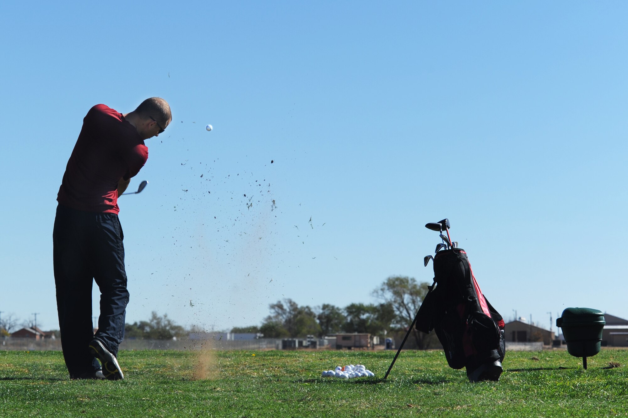 U.S. Air Force Senior Airman Nicholas Tucci, 27th Special Operations Communications Squadron, hits a ball during a golf clinic at Cannon Air Force Base, N.M., Oct. 20, 2012.  Two PGA Class A golfers from Texas Tech University gave free instruction to Cannon Airmen and their families as a way of giving back to the military. (U.S. Air Force photo/Senior Airman Jette Carr)