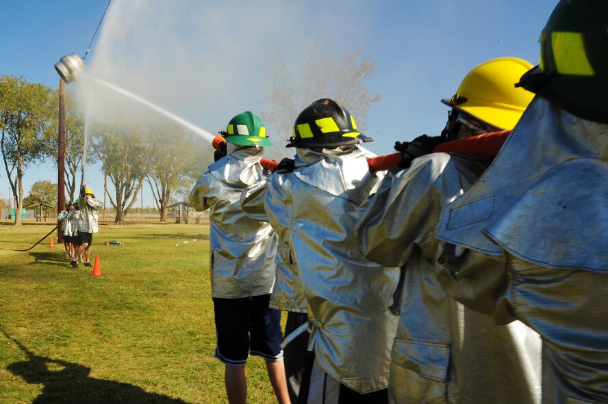 Competitors hit their target with a fire hose during the 14th Annual Fire Muster at Cannon Air Force Base, N.M., Oct. 19, 2012.  This friendly competition serves as a way for squadrons to build teams and foster comradery around base.  (U.S. Air Force photo/Senior Airman Jette Carr)