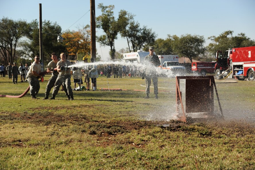 Competitors hit their target with a fire hose during the 14th Annual Fire Muster at Cannon Air Force Base, N.M., Oct. 19, 2012.  This friendly competition serves as a way for squadrons to build teams and foster comradery around base.  (U.S. Air Force photo/Senior Airman Jette Carr)