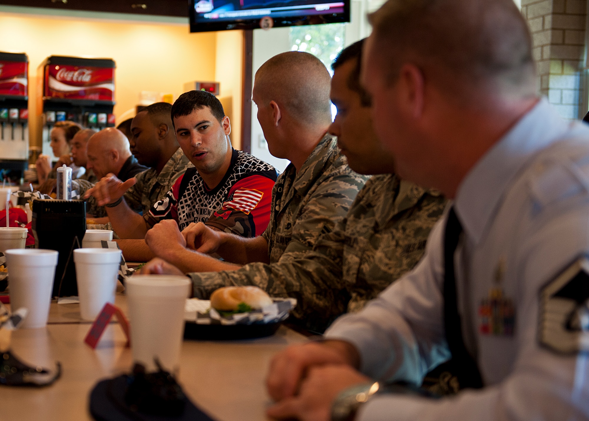 Matias Ferreira, a Wounded Warrior Amputee Softball Team player, talks to players from the Eglin Air Force Base joint military softball team over lunch at Legends restaurant, Oct. 22. The two teams will face off to raise awareness of the sacrifices and resilience of military members Nov. 3 at 5 p.m. at Morgan Sports Center in Destin, Fla. (U.S. Air Force photo/Randy Gon)