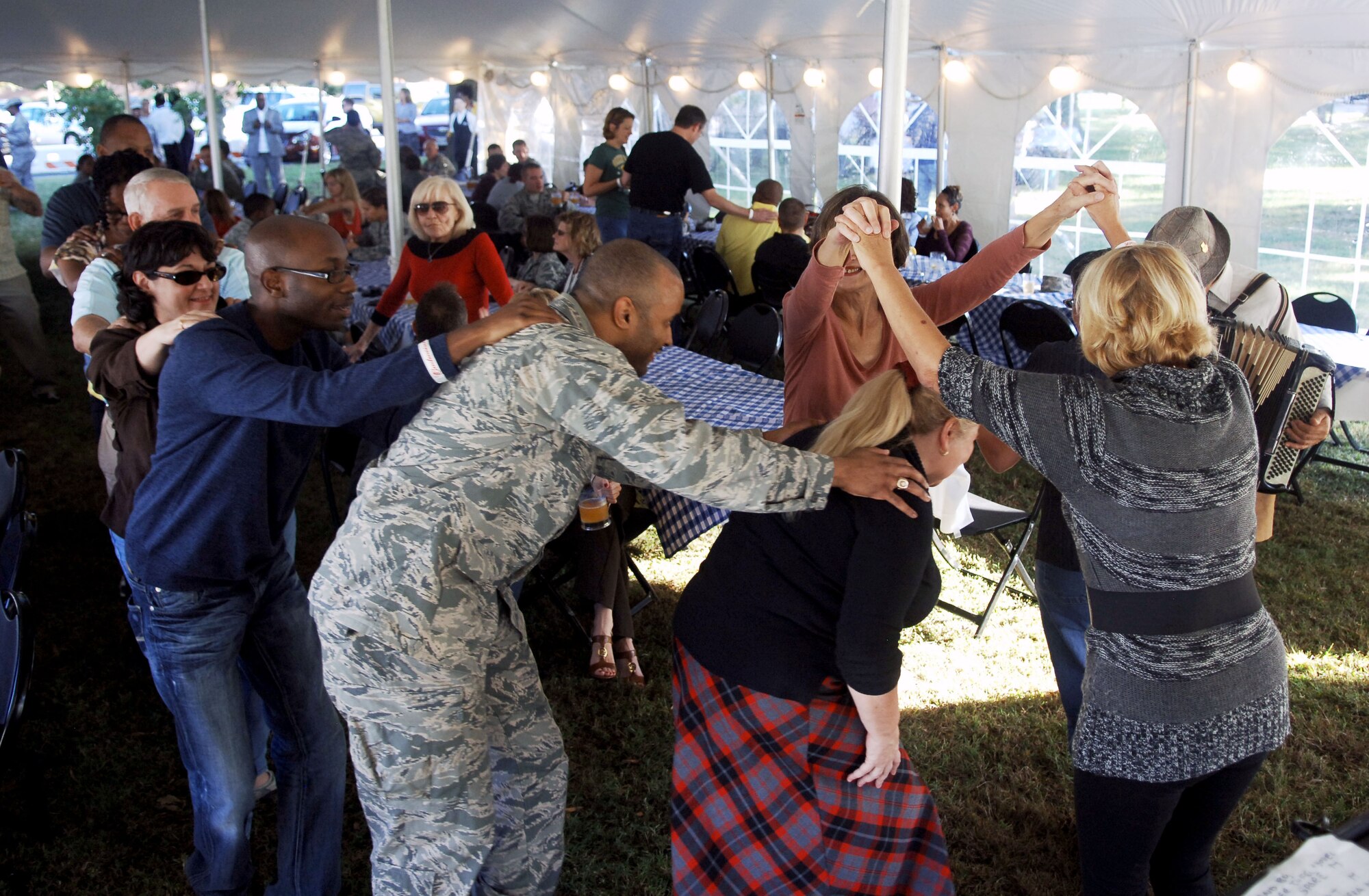 Attendees of Boss & Buddy Oktoberfest dance the “Schneckendanz,” or “Snake Dance” Oct. 19 at the Langley Air Force Base Club.  The “Schneckendanz” was one of the interactive songs performed by the band of the event, The Happy Dutchmen.   (U.S. Air Force photo by Staff Sgt. Katie G. Ward / Released)