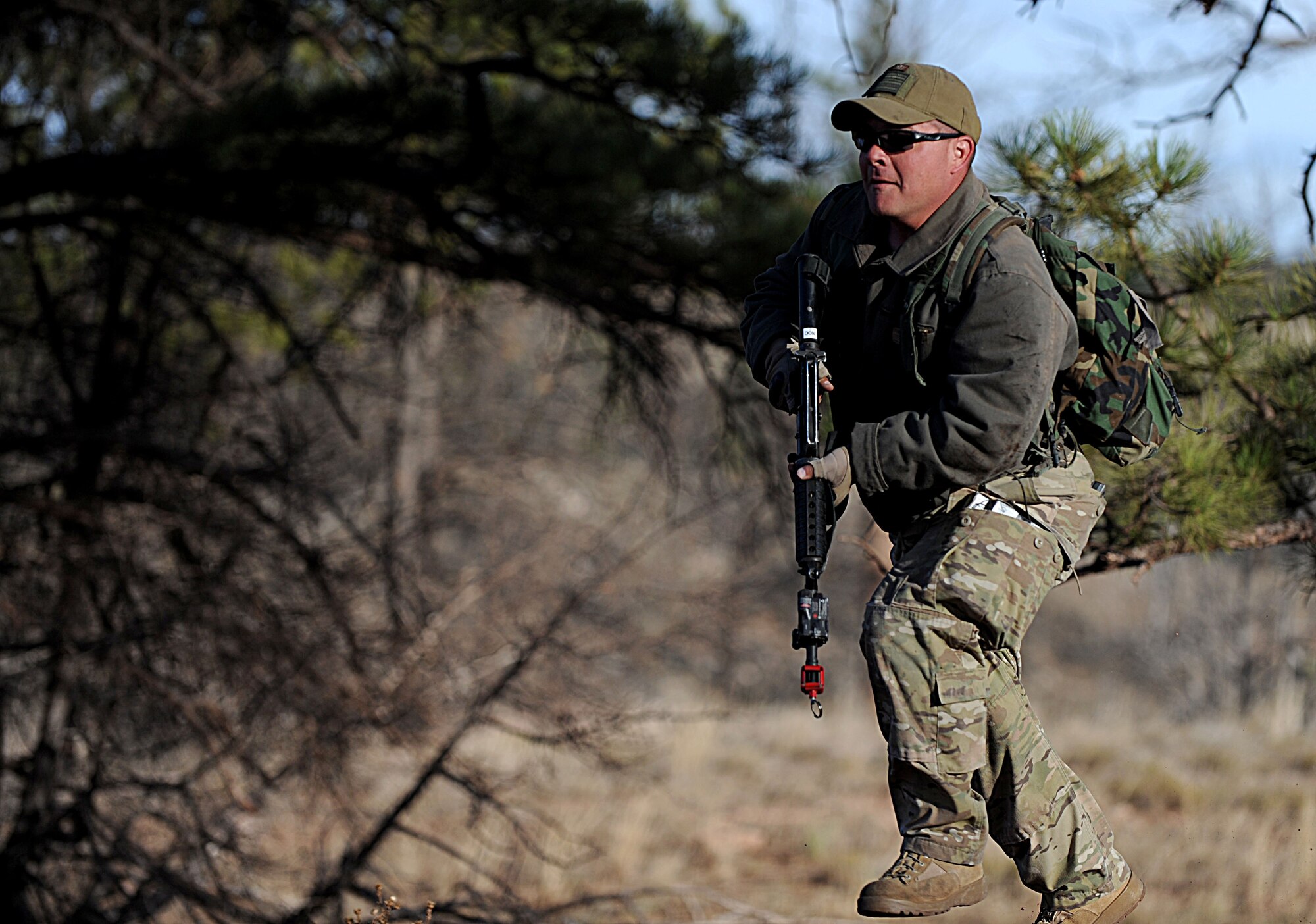 Tech. Sgt. Jeffrey Hutchison, 620th Ground Combat Training Squadron combat arms noncommissioned officer-in-charge, charges a rolling convoy while posing as an opposing force team member during the Road Warrior exercise at Camp Guernsey, Wyo., Oct. 19, 2012. The Op-4 teams provide realistic threat scenarios to airmen learning how to properly safeguard, transport and recover a nuclear resource. (U.S. Air Force photo by Senior Airman Jarad A. Denton/Released)

