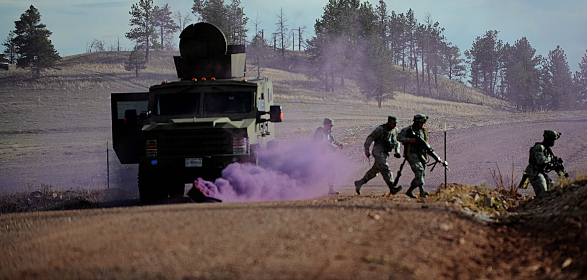 Security Forces Airmen from F.E. Warren Air Force Base, Wyo., use smoke to cover their movements as they sweep the area for potential threats during the Road Warrior exercise at Camp Guernsey, Wyo., Oct. 19, 2012. During the exercise, Airmen are taught to achieve 360-degree security when responding to threats against a nuclear convoy. (U.S. Air Force photo by Senior Airman Jarad A. Denton/Released)
