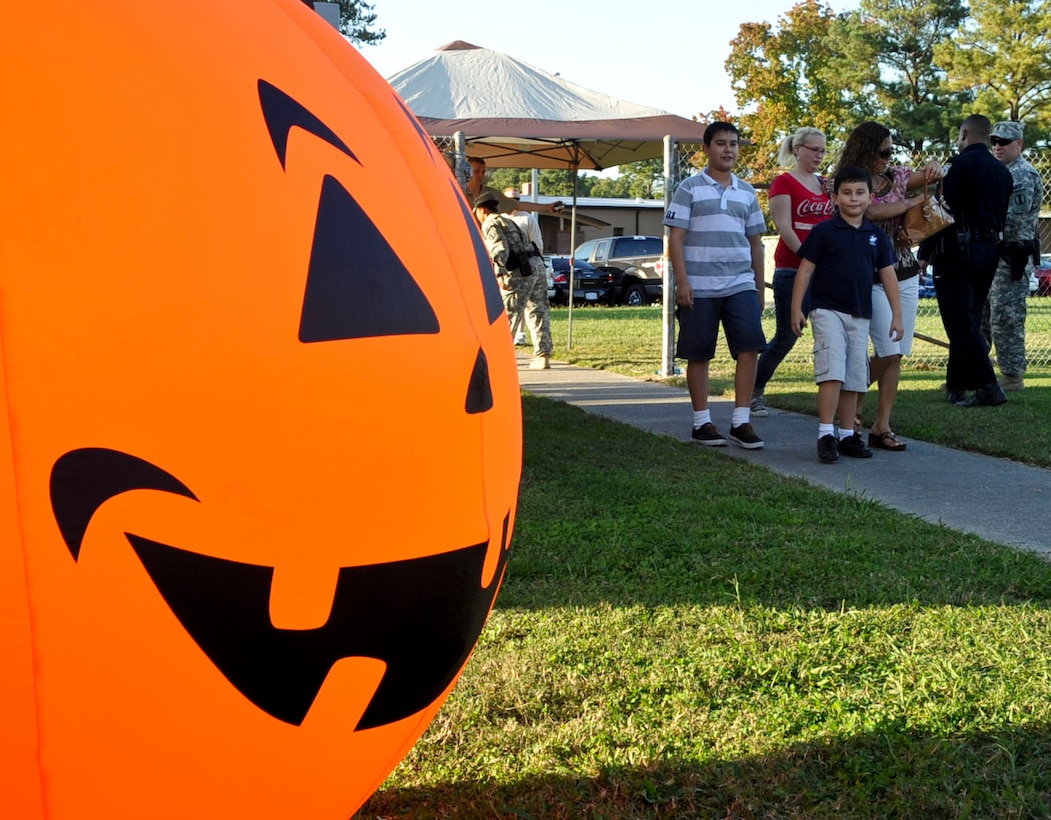 A giant pumpkin greets a family as it enters Murphy field for the first annual Fall Festival held at Fort Eustis, Va., Oct. 19, 2012. The free event offered a variety of family friendly events including a hay rides, live music, bouncy houses, and paint ball. (U.S. Air Force photo by Staff Sgt. Wesley Farnsworth / Released)