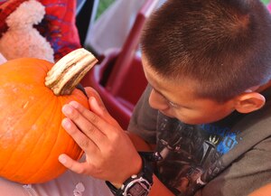 Nine-year-old Luis Giron, decorates a pumpkin at the Fort Eustis Youth Center’s table at the first annual Fall Festival held at Fort Eustis, Va., Oct. 19, 2012. The free event also offered hay rides, live music, bouncy houses, paint ball and more to those attending. (U.S. Air Force photo by Staff Sgt. Wesley Farnsworth / Released)