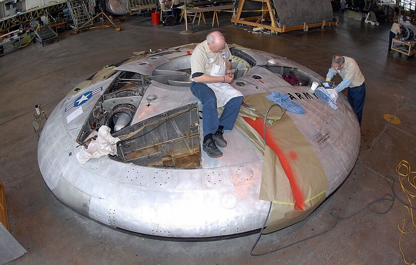 Volunteers Ed Keinle and Lou Thole remove rivets from the Avro Canada VZ-9AV Avrocar in the restoration hangar at the National Museum of the United States Air Force at Wright-Patterson Air Force Base, Ohio. Although the Avrocar was never implemented, museum officials feel it serves as a successful teaching tool. (U.S. Air Force photo)