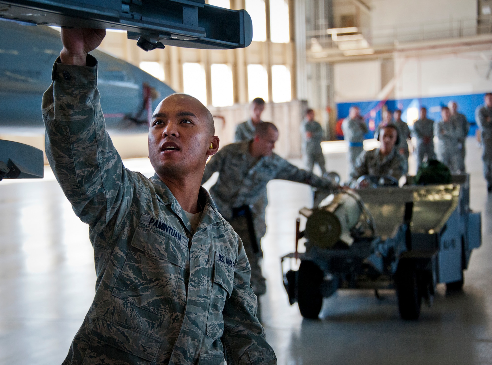 Senior Airman Adrian Pamintuan, of the 96th Aircraft Maintenance Squadron, double checks the connecters on the F-16 wing as his teammates move an MK-82 to be loaded during a weapons load competition Oct. 19 at Eglin Air Force Base, Fla.  Pamintuan and his team competed in the quarterly competition against an F-15 load crew team.  The competition was measured by how quickly, safely and accurately the teams loaded an MK-82 and an AIM-9M to their respective aircraft.  (U.S. Air Force photo/Samuel King Jr.)