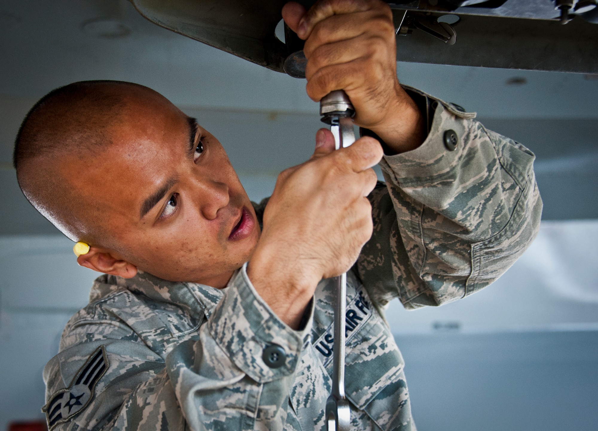 Senior Airman Adrian Pamintuan, of the 96th Aircraft Maintenance Squadron, loosens a bolt on an F-16 prior to mounting a bomb to the wing during a weapons load competition Oct. 19 at Eglin Air Force Base, Fla.  Pamintuan and his team competed in the quarterly competition against an F-15 load crew team.  The competition was measured by how quickly, safely and accurately the teams loaded an MK-82 and an AIM-9M to their respective aircraft.  (U.S. Air Force photo/Samuel King Jr.)