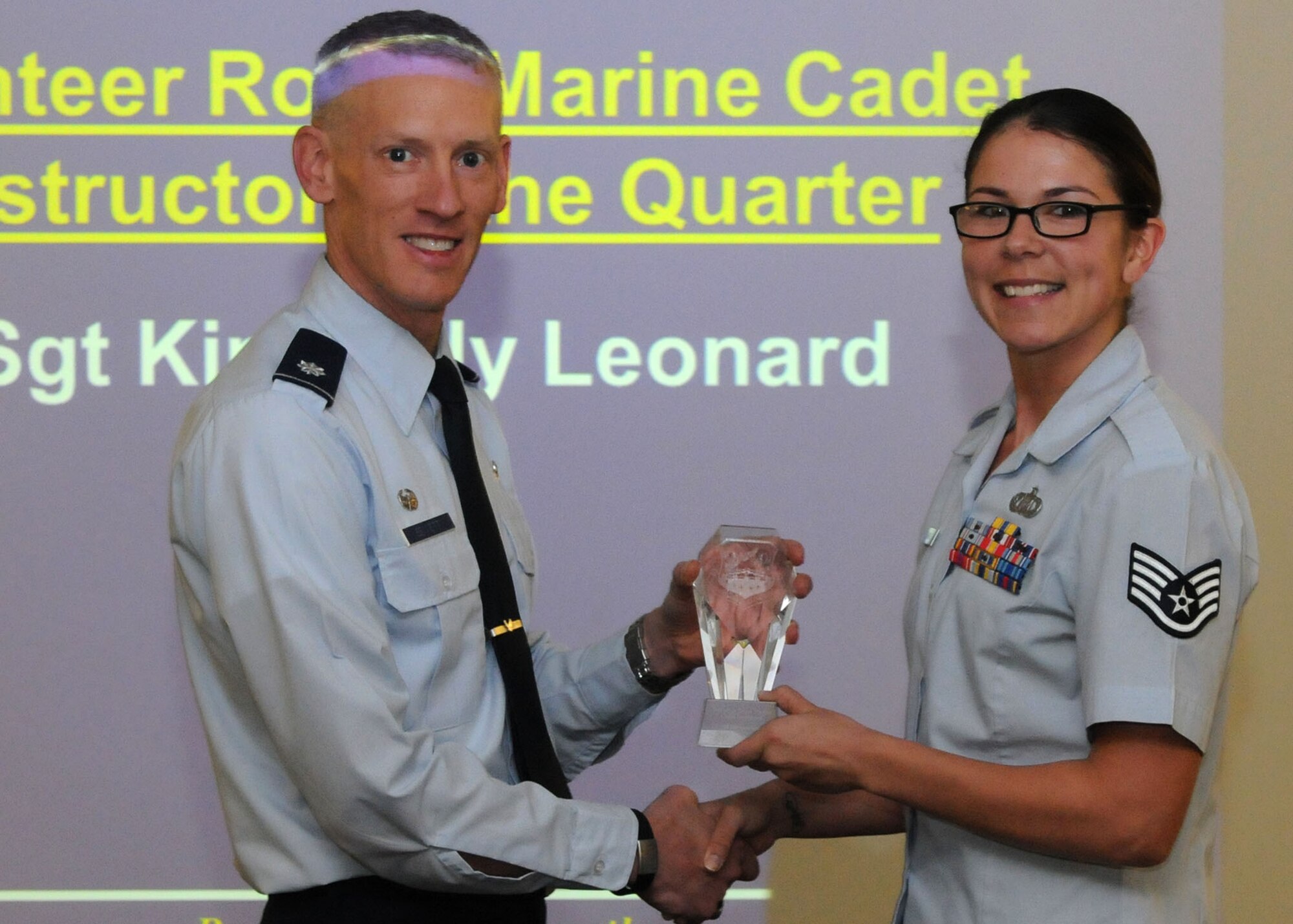 Staff Sgt. Kimberly Leonard, 100th Operations Support Squadron aviation resource manager receives the Volunteer Royal Marine Cadet Instructor of the Quarter award from Lt. Col. Christopher Bennett, 100th Operations Support Squadron commander, Oct. 22, 2012, on RAF Mildenhall, England, on behalf of the TS Intrepid Royal Marine Red Lodge Cadets. Leonard was recognized after contributing more than 100 hours of community service as an instructor to the Royal Marine cadets.(U.S. Air Force Photo by Airman 1st Class Kelsey Waters)
