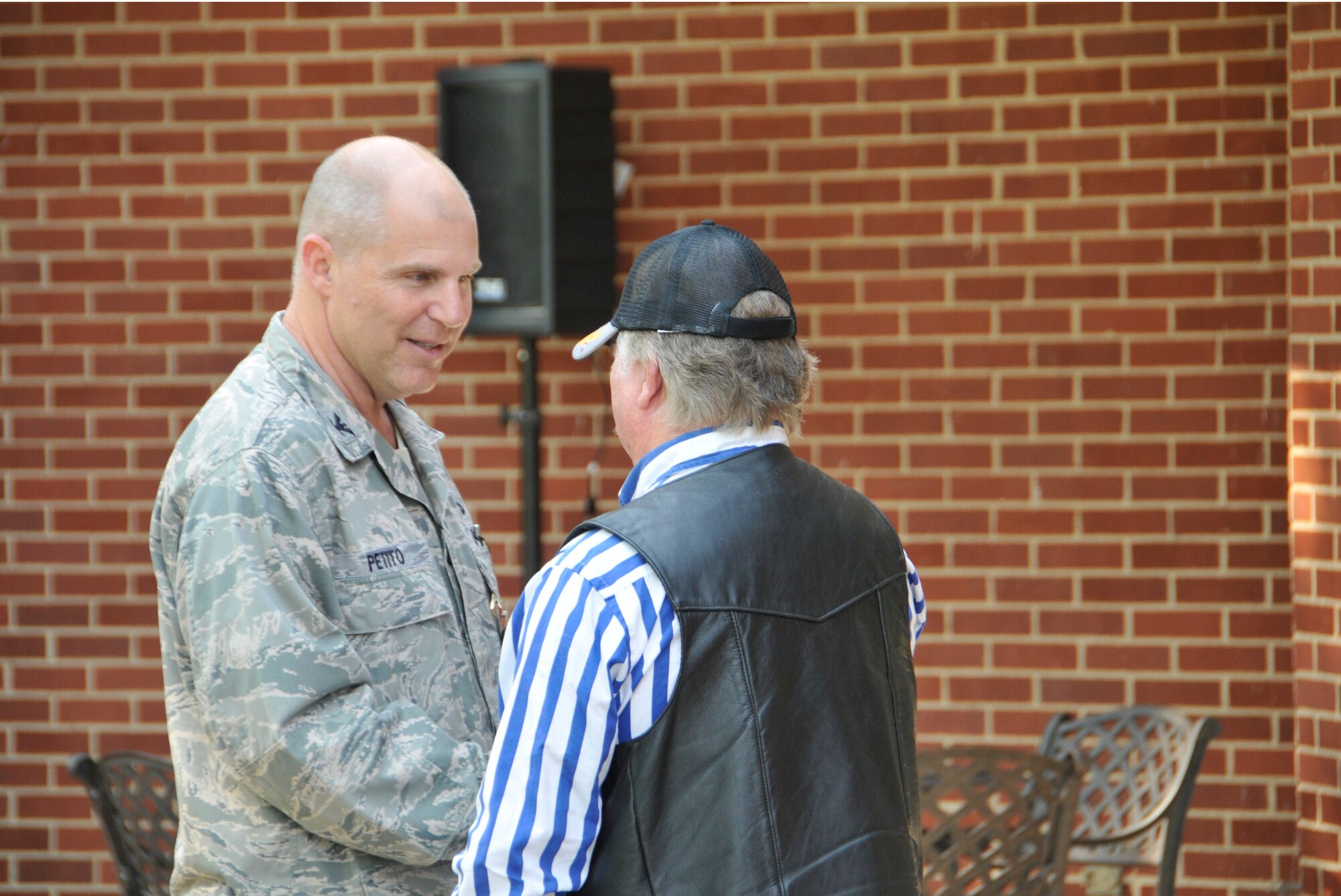 Left, AEDC Maintenance Division Deputy Col. Rick Petito greets veteran and Tenn. State Veterans Home resident Billy Campbell, one of the veterans who attended this year’s VA Picnic before Arnold’s Fire Department volunteers served the meal at the base’s Lakeside Center. (Photo by Rick Goodfriend)
