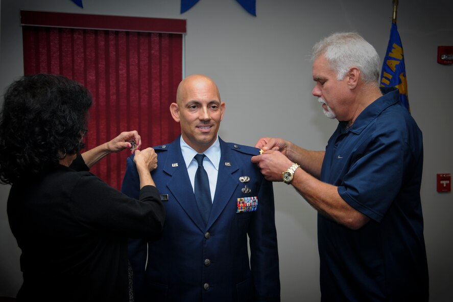 Frank A. Mercurio, 911th Airlift Wing process manager, is pinned with the rank of major by his parents, Ed and Maryann Cooper, during a promotion ceremony held here, Oct. 13, 2012. Mercurio achieved the rank of major after serving 10 years as an enlisted member and nine years as an officer.  He has served in both the active and reserve components of the Air Force. (U.S. Air Force photo by Senior Airman Joshua J. Seybert/Released)