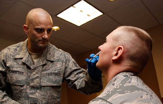 Tech. Sgt. Keith Schmocker, Aeromedical Staging Squadron medical technician, administers influenza nasal spray to Airman Garrett Railing, 32nd Aerial Port Squadron air transportation apprentice, Oct. 13, 2012. A team of medical technicians spent most of their unit training assembly distributing the Flu mist and shot vaccinations to Airmen of the 911th Airlift Wing, which is required for all Airmen to protect them from illness during the flu season. (U.S. Air Force photo by Senior Airman Justyne Obeldobel/Released)