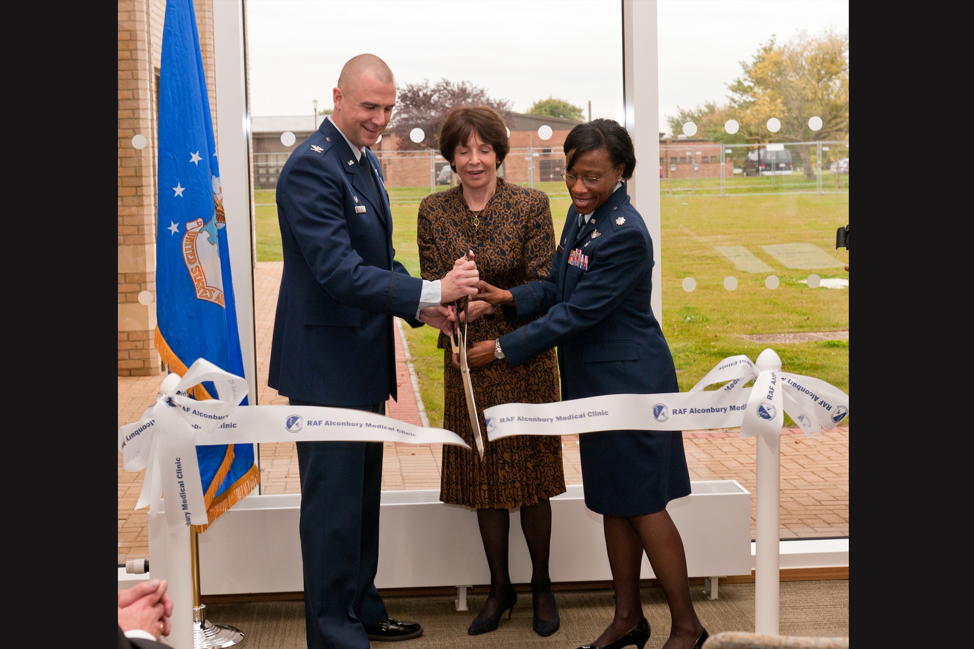 RAF ALCONBURY, United Kingdom – (Left to right) Col. Michael Reiner, 423rd ABG commander, Dame Mary Archer, Cambridge University Hospital chairman and 423rd Medical Squadron honorary commander, and Lt. Col. Cherron Galluzzo, 423rd MDS commander, cut the ribbon the RAF Alocnbury Clinic Oct. 19. The ribbon cutting at the RAF Alconbury Clinic is the first step in many the U.S. Department of Defense is taking in returning the RAF Upwood Clinic back to the host nation. The return of this site is part of U.S. European Command’s (USEUCOM) continued effort to remove non-enduring sites, bases and installations from its real-property inventory. (U.S. Air Force photo by Staff Sgt. Brian Stives)