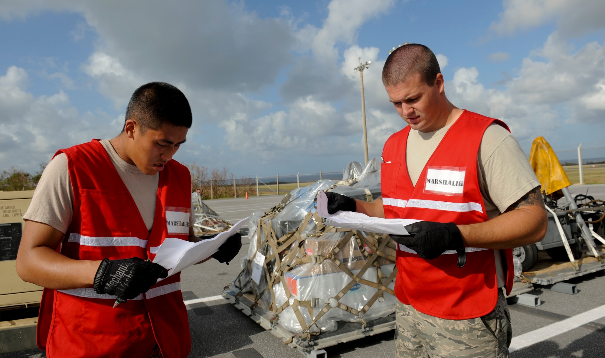 Airmen 1st Class Justin Bow and Matthew Lester, 18th Logistics Readiness Squadron vehicle maintainers, discuss plans to load cargo onto a C-17 Globemaster III during a Pacific Air Forces readiness inspection on Kadena Air Base, Japan, Oct. 22, 2012. Kadena Airmen are being tested on how prepared they are to handle real-world contingencies. (U.S. Air Force photo/Airman 1st Class Hailey R. Davis)