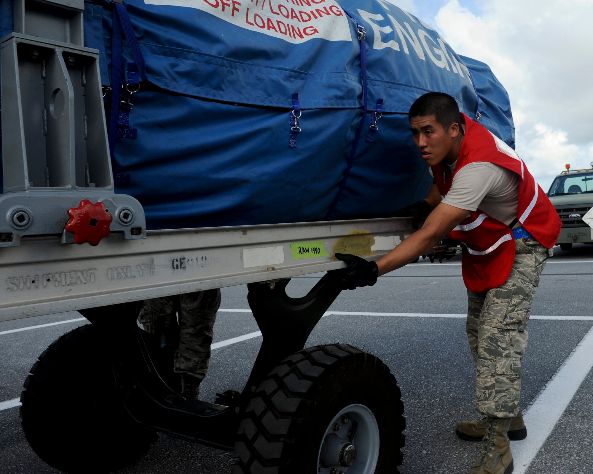 Airman 1st Class Justin Bow, 18th Logistics Readiness Squadron vehicle maintainers, pushes a jet engine between chalk lines representing the floor plan of a C-17 Globemaster III during a Pacific Air Forces readiness inspection at Kadena Air Base, Japan, Oct. 22, 2012. Kadena Airmen are being tested on how prepared they are to handle real-world contingencies. (U.S. Air Force photo/Airman 1st Class Hailey R. Davis)