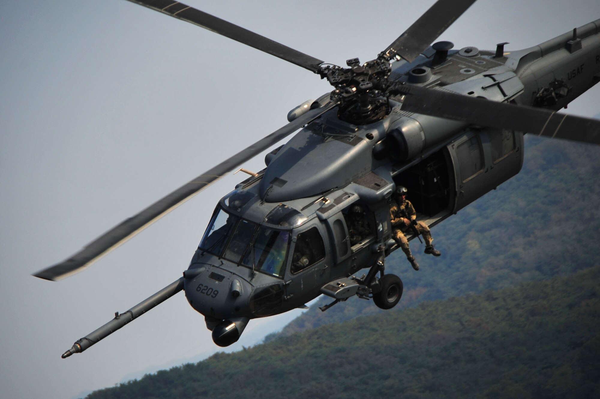 Airmen of the 33rd Rescue Squadron fly an HH-60 Pave Hawk during Osan Air Base, Republic of Korea, Air Power Day, Oct. 20, 2012. The Airmen participated in the air show to help highlight the relationship between them and the Koreans through public demonstrations of military equipment and personnel. (U.S. Air Force photo/Staff Sgt. Sara Csurilla)
