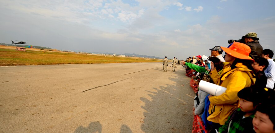 Members of the local community near Osan Air Base, Republic of Korea watch as Airmen of the 33rd and 31st Rescue Squadrons perform a rescue mission during Osan's Air Power Day, Oct. 20, 2012. The Airmen participated in the airshow to help highlight the relationship between them and the Koreans through public demonstrations of military equipment and personnel. (U.S. Air Force photo/Staff Sgt. Sara Csurilla)