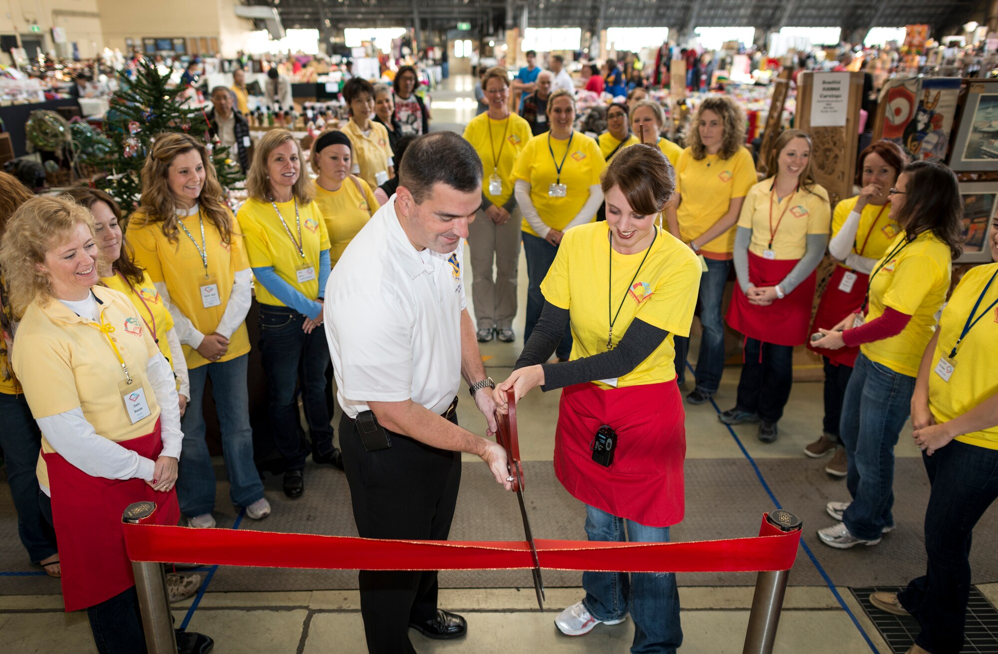 YOKOTA AIR BASE, Japan -- Col. Mark August, center-left, 374th Airlift Wing commander, cuts a ceremonial ribbon with Kallie Culver, Yokota Officers' Spouses' Club Asian Bazaar committee chair, at the opening of the Asian Bazaar at Yokota Air Base, Japan, Oct. 20, 2012. The YOSC hosts the event to raise money for Yokota morale and welfare programs. (U.S. Air Force photo by Tech. Sgt. Samuel Morse)