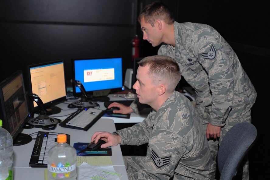 Staff Sgt. Timothy Dent (sitting) and Staff Sgt. Perry Vitali, 51st Security Forces Squadron Combat Readiness Course instructors, run the Engagement Skills Trainer 2000 at Osan Air Base, Republic of Korea, Oct. 4, 2012.  The trainer provides virtual shoot or no-shoot scenarios to help Airmen differentiate between hostile and non-hostile forces in combat situations. (U.S. Air Force photo/Airman 1st Class Alexis Siekert)