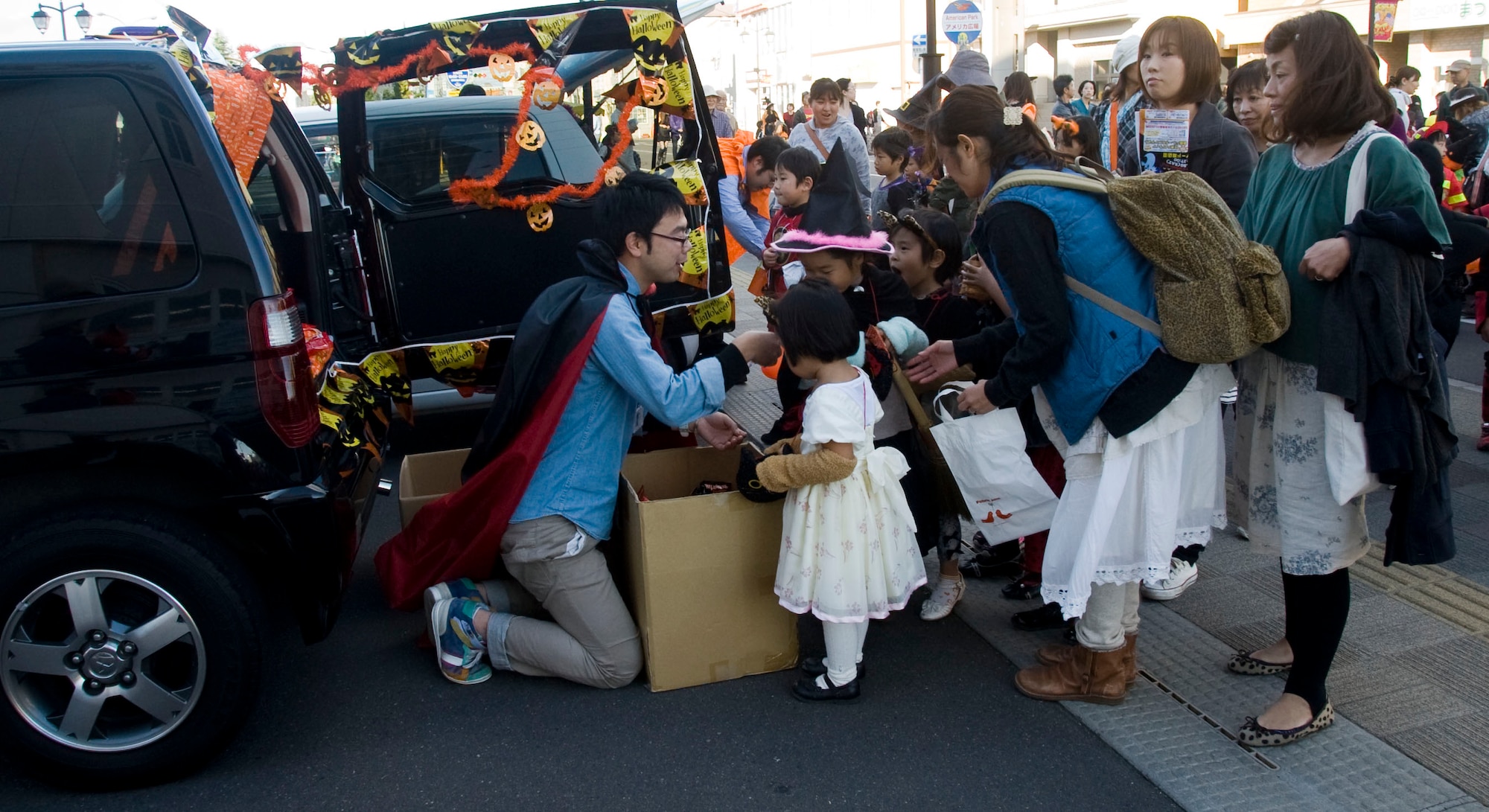 A Japanese national distributes candy to trick-or-treaters on Main Street in Misawa City, Japan, Oct. 20, 2012. Local store owners and friendly members of the Misawa community filled eager children’s bags with sugary sweets from 3 p.m. to 5 p.m. (U.S. Air Force photo by Airman 1st Class Kenna Jackson)