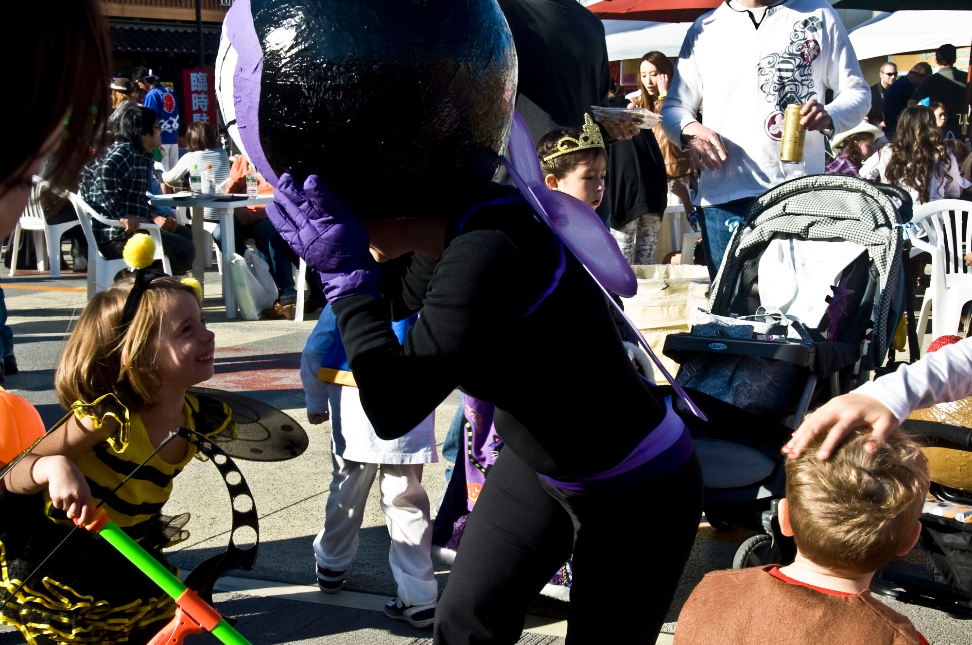 Individuals dressed as a bumble bee and giant fly laugh and dance together during the Misawa Halloween Festival at Sky Plaza in Misawa City, Japan, Oct. 20, 2012. The festival allows Americans to share their Halloween traditions with Japanese families in an effort to strengthen bilateral relationship. (U.S. Air Force photo by Airman 1st Class Kenna Jackson)