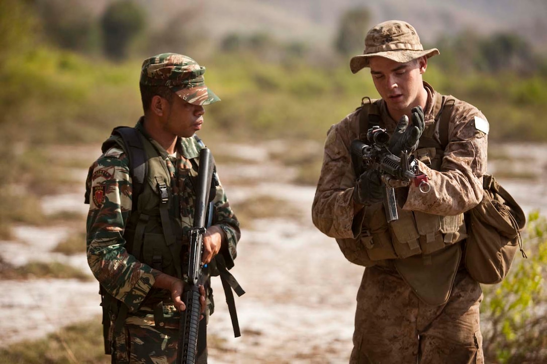 A U.S. Marine from Battalion Landing Team 3/5, 15th Marine Expeditionary Unit, shows a solider with the Timor-Leste Defense Force speed reloading techniques as part of Exercise Crocodilo in Metinaro, Timor-Leste, October 13, 2012. Throughout the exercise forces will participate in various field exercises and community relations aimed at strengthening the relationship between US and Timor-Leste. (U.S. Marine Corps photo by Cpl. Bobby J. Gonzalez)