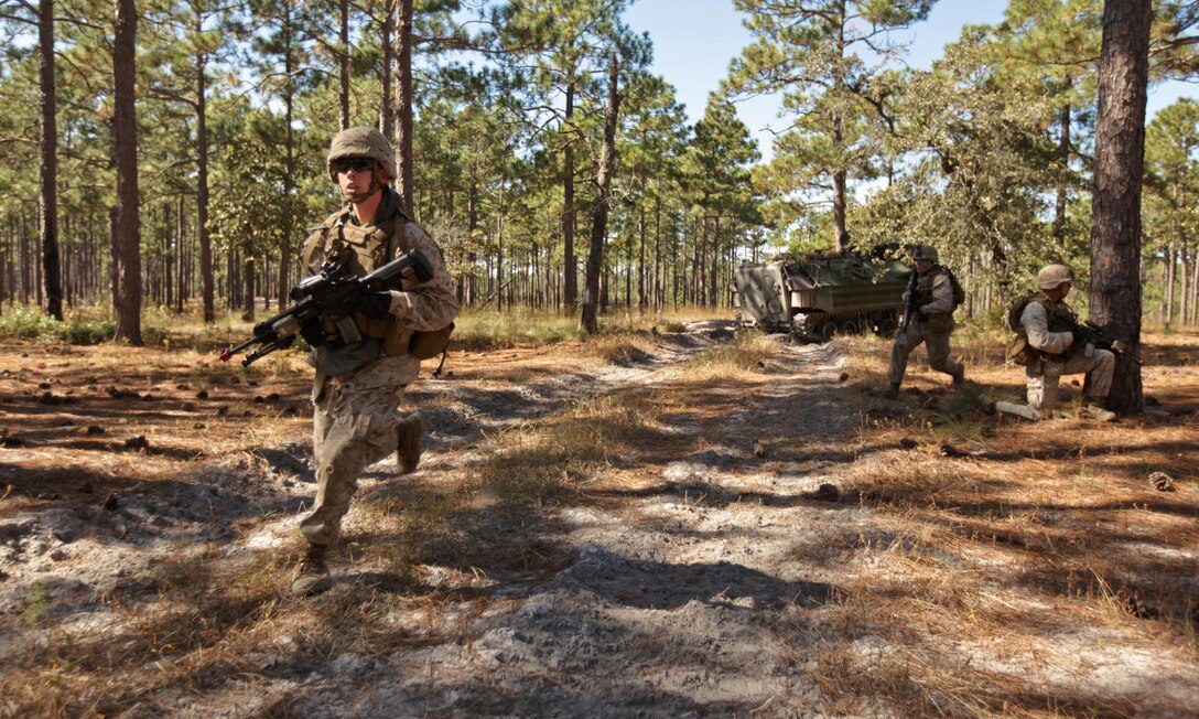 Marines with Company K, Battalion Landing Team 3rd Battalion, 2nd Marine Regiment, 26th Marine Expeditionary Unit, run to fighting positions during a mechanized raid exercise aboard Marine Corps Base Camp Lejeune, N.C., Oct. 16. Marines with Special Operations Training Group, II Marine Expeditionary Force, trained the Marines of the 26th MEU in mechanized raid operations for two weeks in October. 