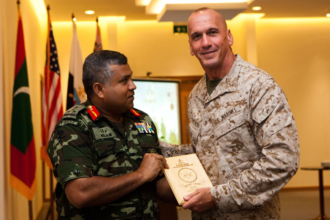 Brig. Gen. Ahmed Nilam, highest-ranking Marine in the Maldivian National Defense Force, presents a plaque to Brig. Gen Richard L. Simcock, deputy commanding general of U.S. Marine Corps Forces, Pacific, during a ceremony here Oct. 17, following the conclusion of Exercise Coconut Grove 2012. The exercise is a bilateral training event conducted bi-annually between the U.S. Marine Corps and the Maldivian National Defense Force, focusing on general military skills.
