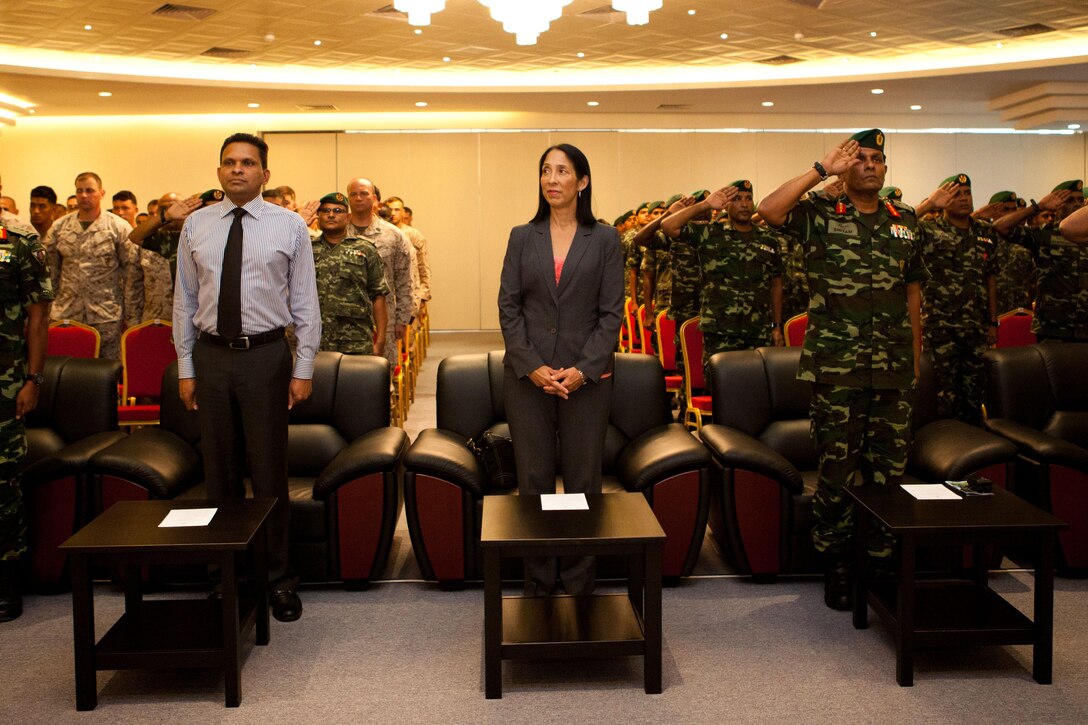 The audience stands for the playing of the Maldivian and American national anthems here Oct. 17, during the closing ceremony for Exercise Coconut Grove 2012. The exercise is a bilateral training event conducted bi-annually between the U.S. Marine Corps and the Maldivian National Defense Force, focusing on general military skills.