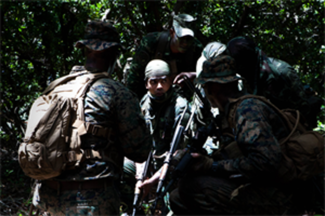 A group of Maldivian and U.S. Marines communicate how they will make it to their objective during a raid here Oct. 16 as part of Exercise Coconut Grove 2012. The exercise is a bilateral training event conducted bi-annually between the U.S. Marine Corps and the Maldivian National Defense Force.