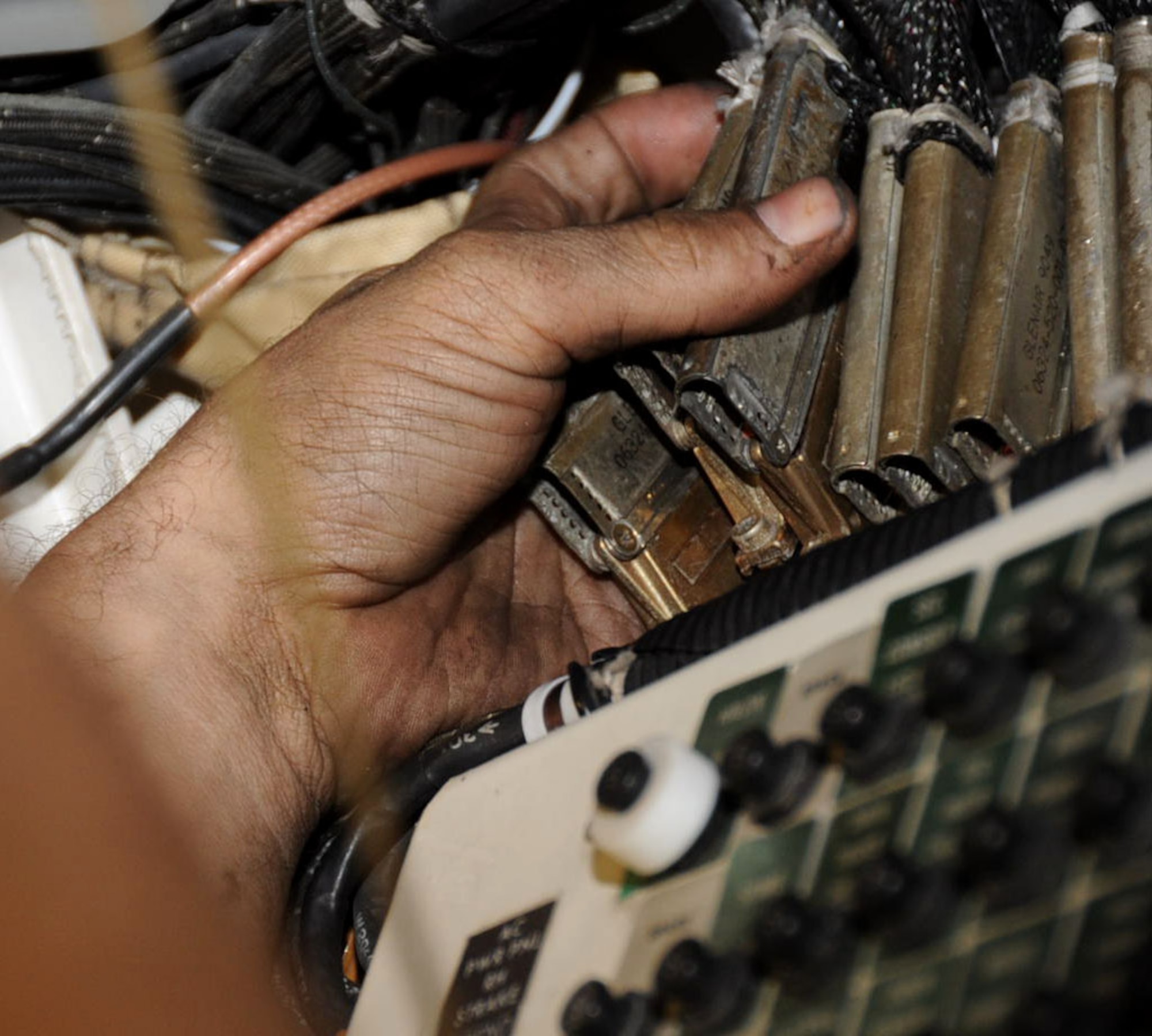 U.S. Air Force Staff Sgt. Kenneth Boswell, 35th Aircraft Maintenance 14th Aircraft Maintenance Unit electrical and environmental craftsman, observes electrical connectors while removing a damaged harness at Misawa Air Base, Japan, Oct. 12, 2012. Electrical connectors are an electro-mechanical device used for joining electrical circuits. (U.S. Air Force photo by Airman 1st Class Kenna Jackson)