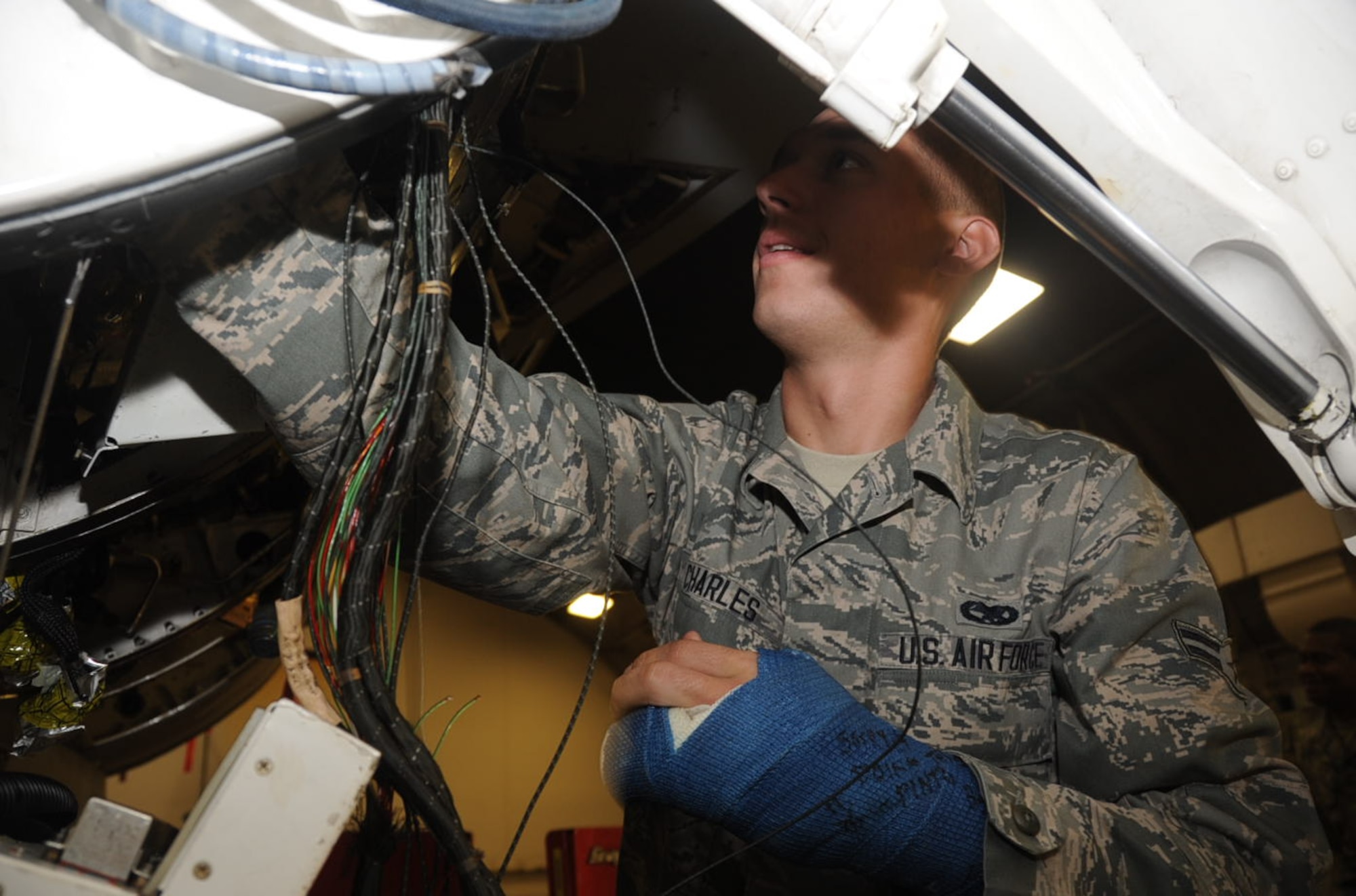 U.S. Air Force Airman 1st Class Daniel Charles, 14th Aircraft Maintenance Unit electrical and environmental team member, works on removing a harness from an F-16 Fighting Falcon aircraft at Misawa Air Base, Japan, Oct. 11, 2012. The 14 AMU E&E team replaced the damaged harness and performed a system check in two weeks. (U.S. Air Force photo by Airman 1st Class Kenna Jackson)