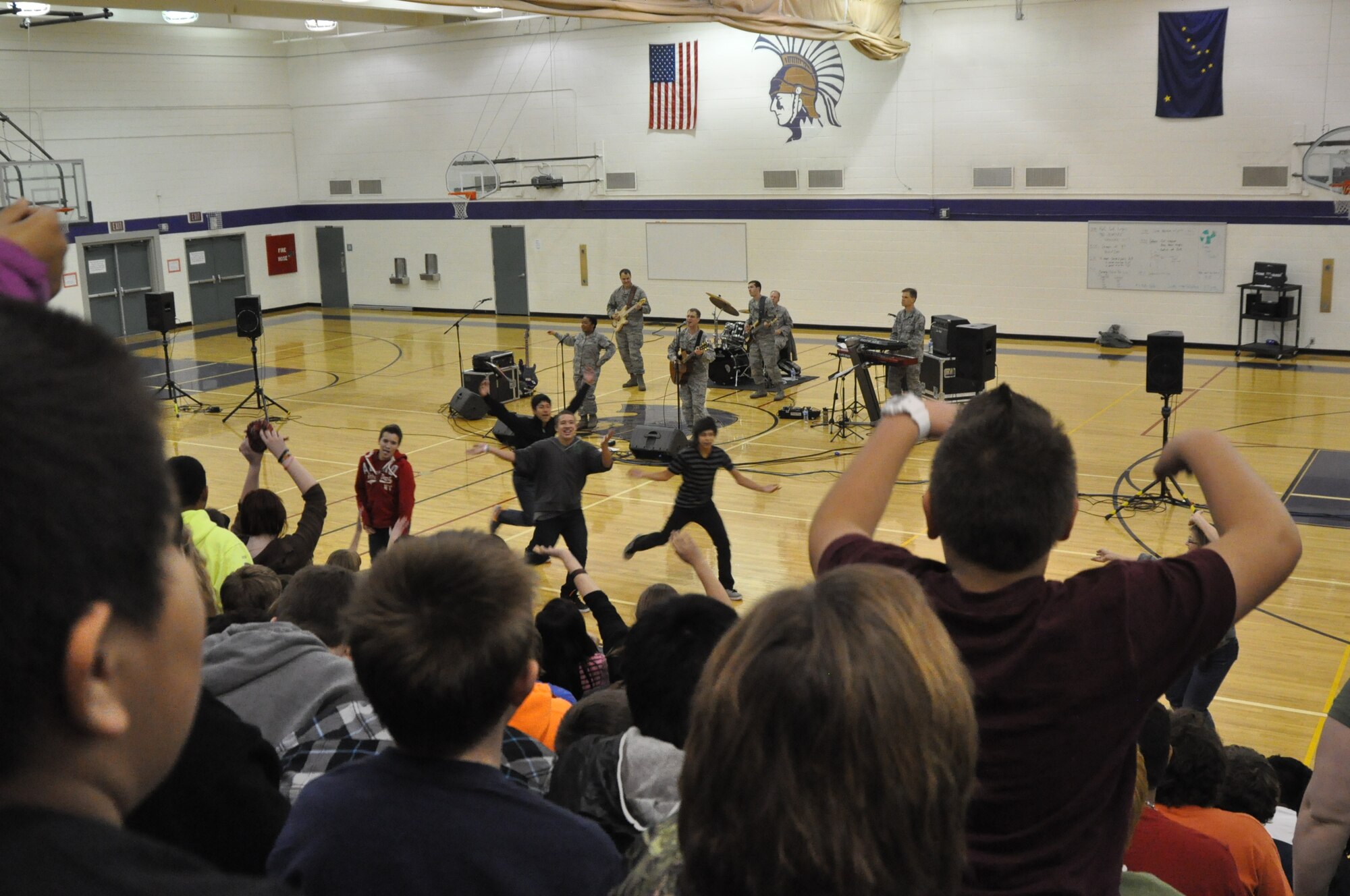 In support of Red Ribbon Week, the USAF Band of the Pacific-Top Cover performs for students in the Anchorage, Palmer, and Wasilla areas. The concerts feature many current musical favorites along with a powerful message to say "NO" to drugs and live a healthy lifestyle.  Pictured here, several student leaders start the wave during a recent concert.