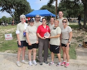 Brig. Gen. Theresa Carter, Joint Base San Antonio and 502nd Air Base Wing Commander, (center) presents the Most Mature Team award to the 50 Shades of Green team Oct. 20 at Joint Base San Antonio Recreation Park, Canyon Lake, Texas.  Pictured from left are: Pat Higgins, Sonia Rivera, John Meyer, Sue Wilson, Jo Grandelli, Larry Smedley and Tina McDaniel. The seventh annual Rambler 120 includes a 22-mile bike course, a 6-mile run and a 2-mile rafting course. (U.S. Air Force photo by Dan J. Solis) 