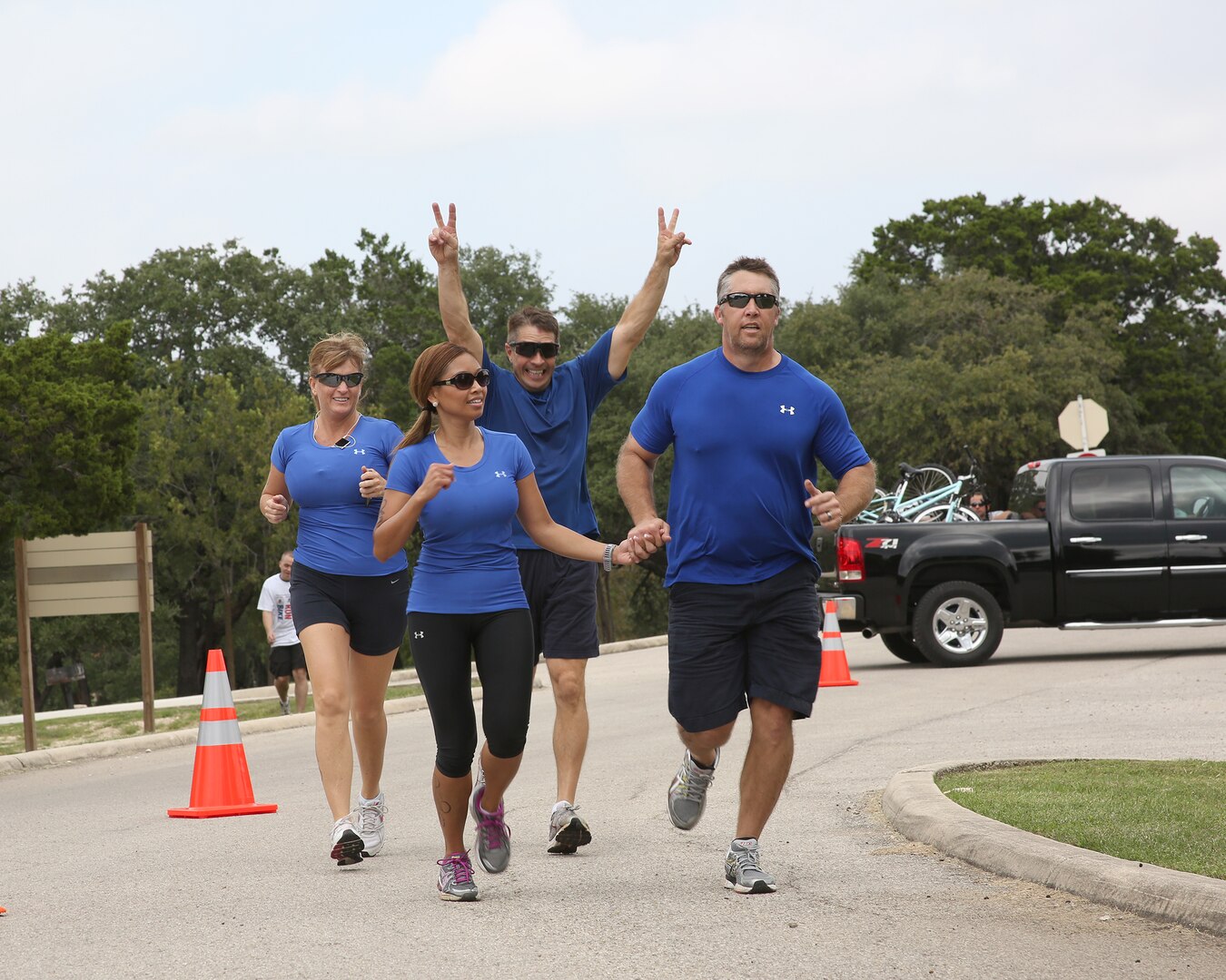 Team Phat Beer Cells crosses the finish line at the Rambler 120 triathlon event held at Joint Base San Antonio Recreation Park, Canyon Lake, Texas, Oct. 20.  Pictured from left are: Penelope Smith, Madelane How, Mike Misenhimer and Sean How.  At the conclusion of the event, Brig. Gen. Theresa Carter, Joint Base San Antonio and 502nd Air Base Wing commander, presented the Finishers Award to the team. (U.S. Air Force photo by Dan J. Solis) 