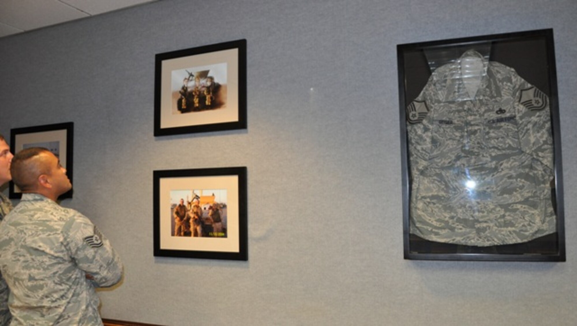 Airey NCO Academy students admire the photos and other memorabilia Class 12-7 decorated their classroom with in honor of Master Sgt. William Geiger, Jr., a vehicle operator recognized for extraordinary action in the line of duty during a deployment to Iraq. Each class renames a flight classroom in honor of a deserving Airman. This is the school's tenth renaming. (U.S. Air Force photo by Staff Sgt. Kirsten Wicker)
