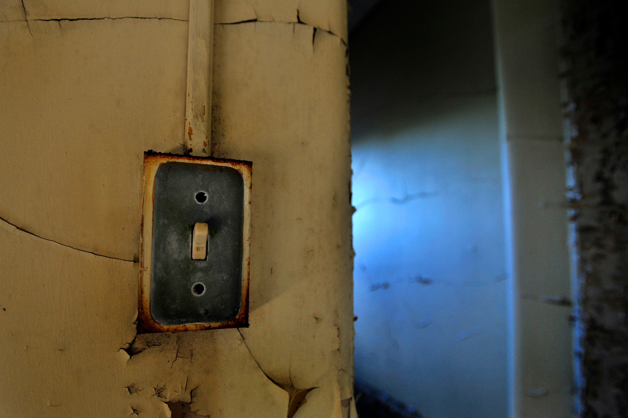 An old, weathered light switch is left in the on position after several years of use, Oct. 20, 2012, Columbia, S.C. The month of October marks National Energy Action Month, which encourages people to conserve energy. One way to aid in the conservation of energy is simply ensuring light switches are turned off when not in use. The switch in this image is located in an abandon insane asylum and no longer consumes energy as the power to the building has been turned off. (U.S. Air Force photo by Staff Sgt. Kenny Holston/Released)